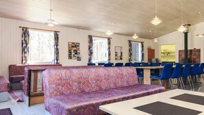 A room with patterned sofas, a dining table, and blue chairs. - 6 Person Holiday Park Home in Laeso (Læsø)