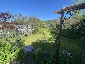 Un jardin agrémenté de diverses plantes et d’une pergola en bois.