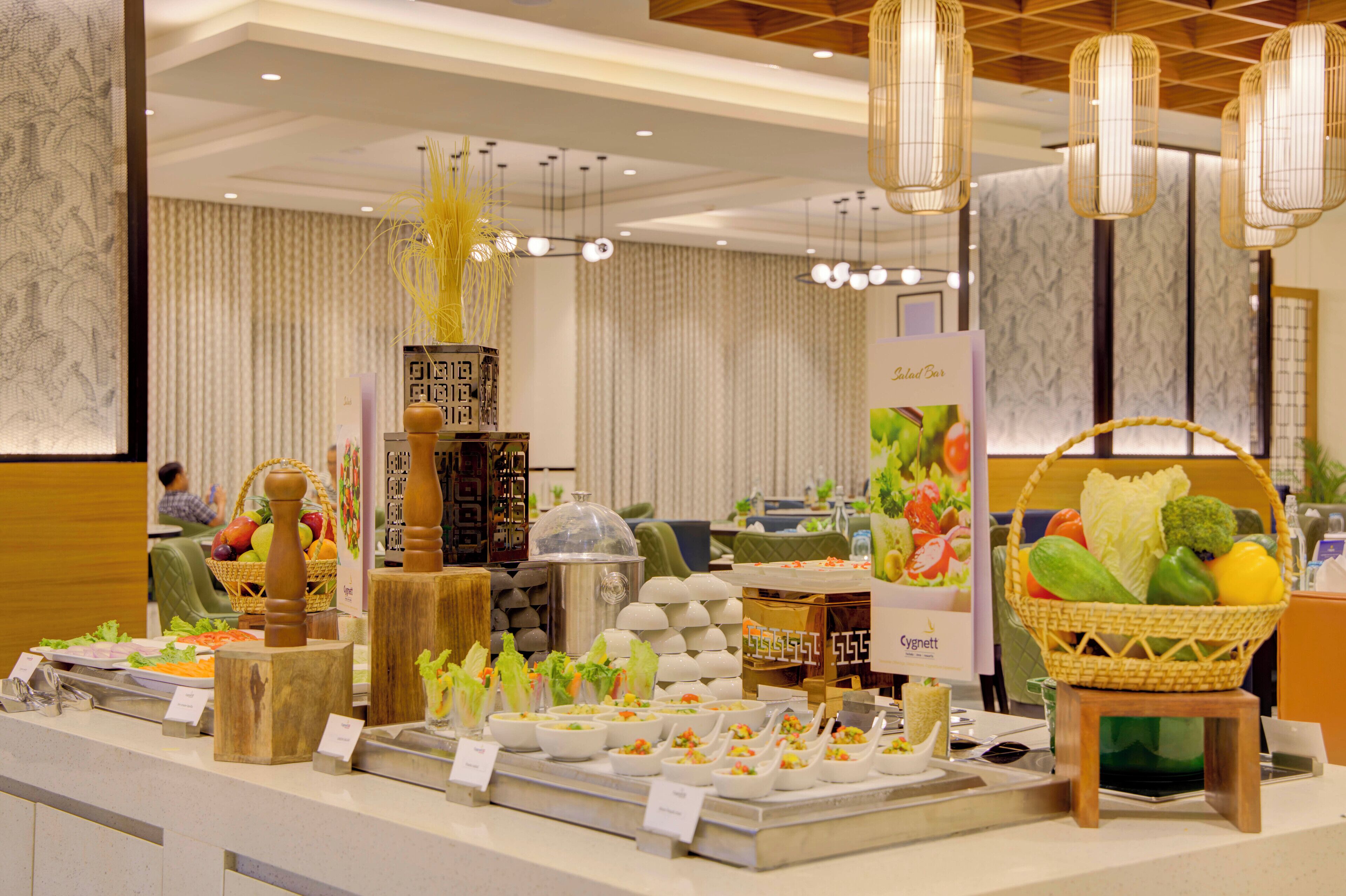 A buffet setup with various food items and a salad bar.