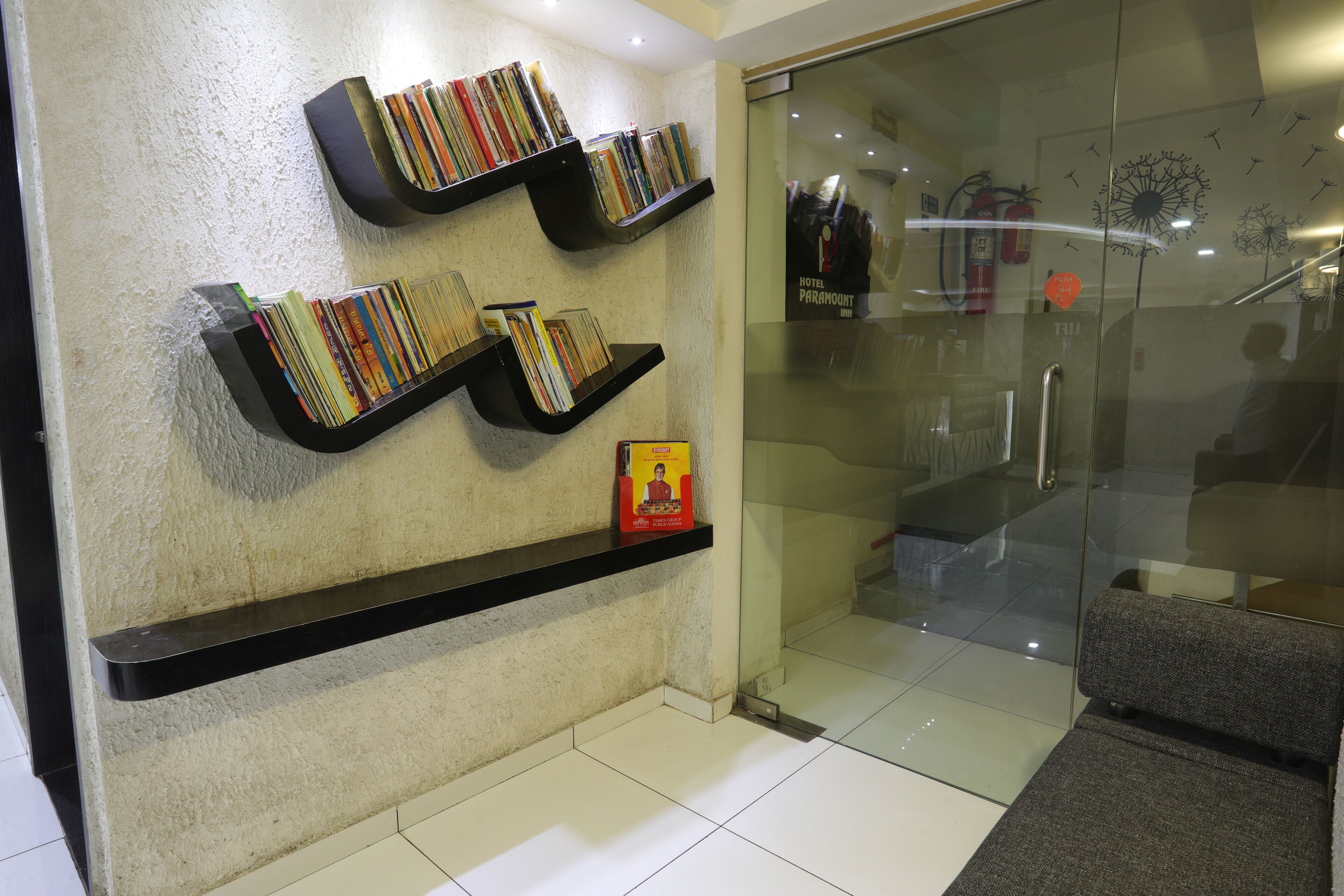 A reception area with a glass door, a fire extinguisher, and a staircase.