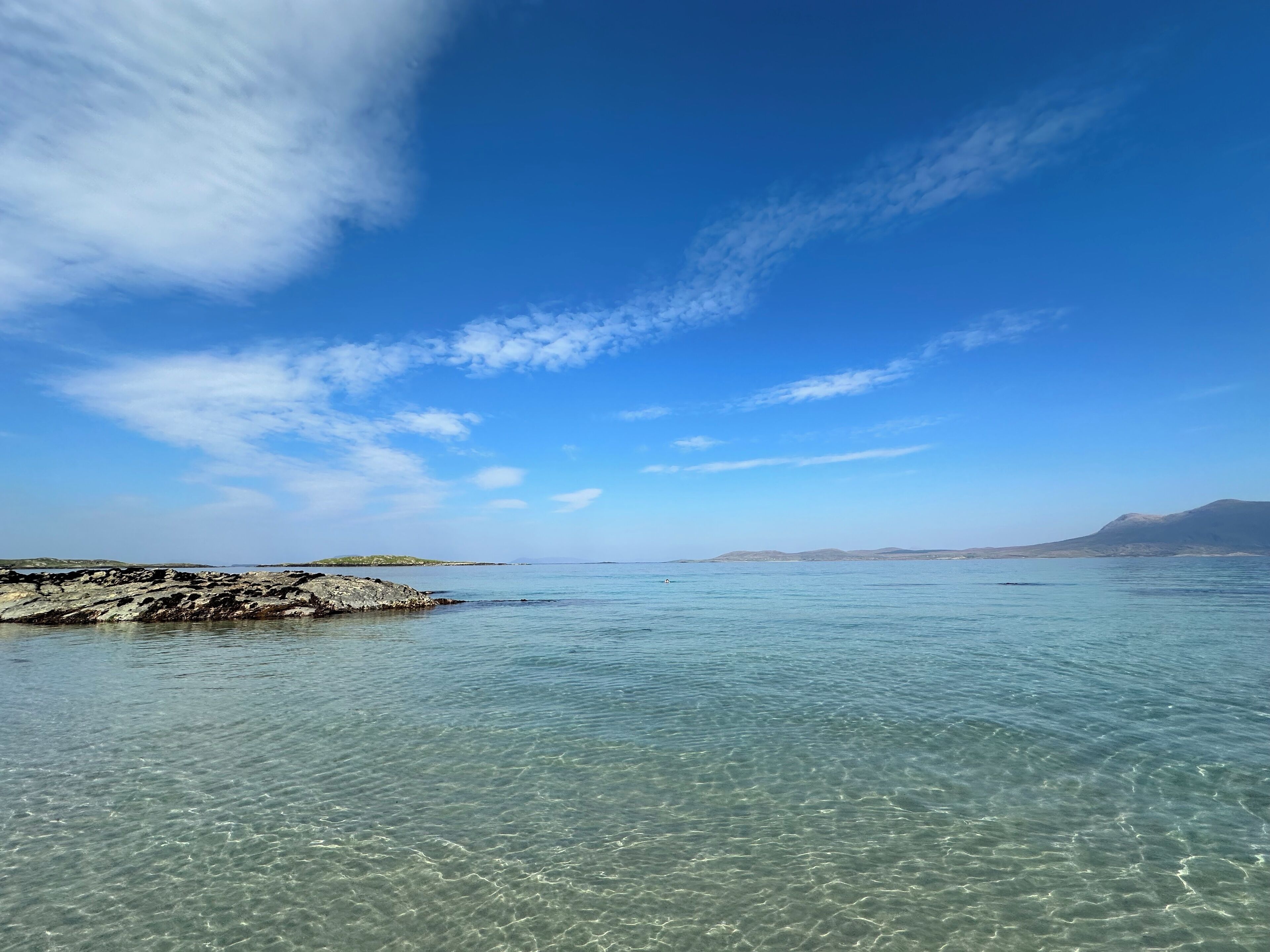 Une vue dégagée sur la côte, avec un rivage rocheux et des eaux calmes.