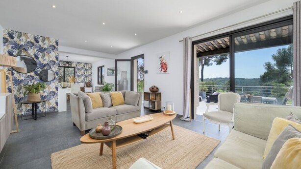A spacious living area with a sofa, coffee table, and a view of the outdoors.
