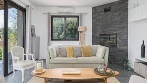 A modern living room with a sofa, a coffee table, and a fireplace.