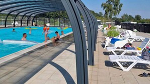 A swimming pool with a covered area and lounge chairs. - 6 Person Holiday Park Home in Malling (Malling)