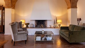 Una sala de estar acogedora con chimenea, dos sillones, un sofá y una mesa de centro.