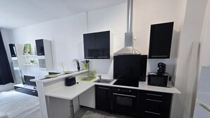 Una cocina moderna con gabinetes negros, una campana extractora de acero inoxidable y un horno empotrado.