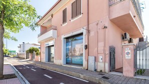 A building with a large glass door, a sign for a business, and a no parking sign. - Beautiful apartment for 2 guests with WIFI, A/C, TV, terrace and pets allowed (Olbia)