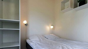 A bedroom with a single bed, a wardrobe, and two wall-mounted light fixtures. - 3 Person Holiday Park Home in Asperup (Middelfart)
