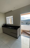 Uma cozinha moderna com uma ilha grande, uma janela e vista para o horizonte urbano.