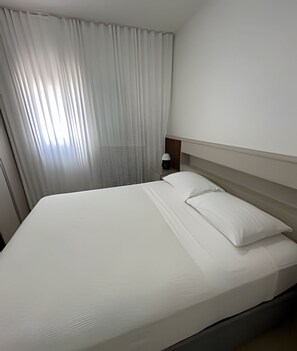 Design Villa | Desk, laptop workspace, blackout drapes, iron/ironing board