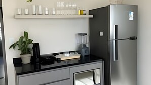Una cuina moderna amb frigorífic integrat, taulell amb amassetge i una planta en test.