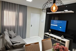 Una sala de estar moderna con un sofá, un televisor y una lámpara decorativa.