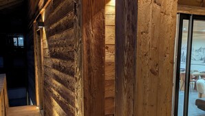 A wooden interior with a wooden staircase leading to a higher level. - Modern chalet La Tanière with sauna in Le Chinaillon (Le Grand-Bornand)