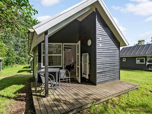 A small, single-story house with a porch, a table, and chairs. - 6 Person Holiday Park Home in Malling (Malling)