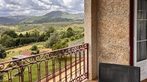 A balcony with a view of a mountainous landscape, a stone wall, and a red metal railing. - Nomad s Country - Cimo de Vila The Valley Terrace (Cabeceiras de Basto)