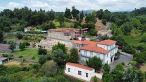 A large, multi-story building with a courtyard, surrounded by lush greenery and a tennis court. - Nomad s Country - Cimo de Vila The Valley Terrace (Cabeceiras de Basto)