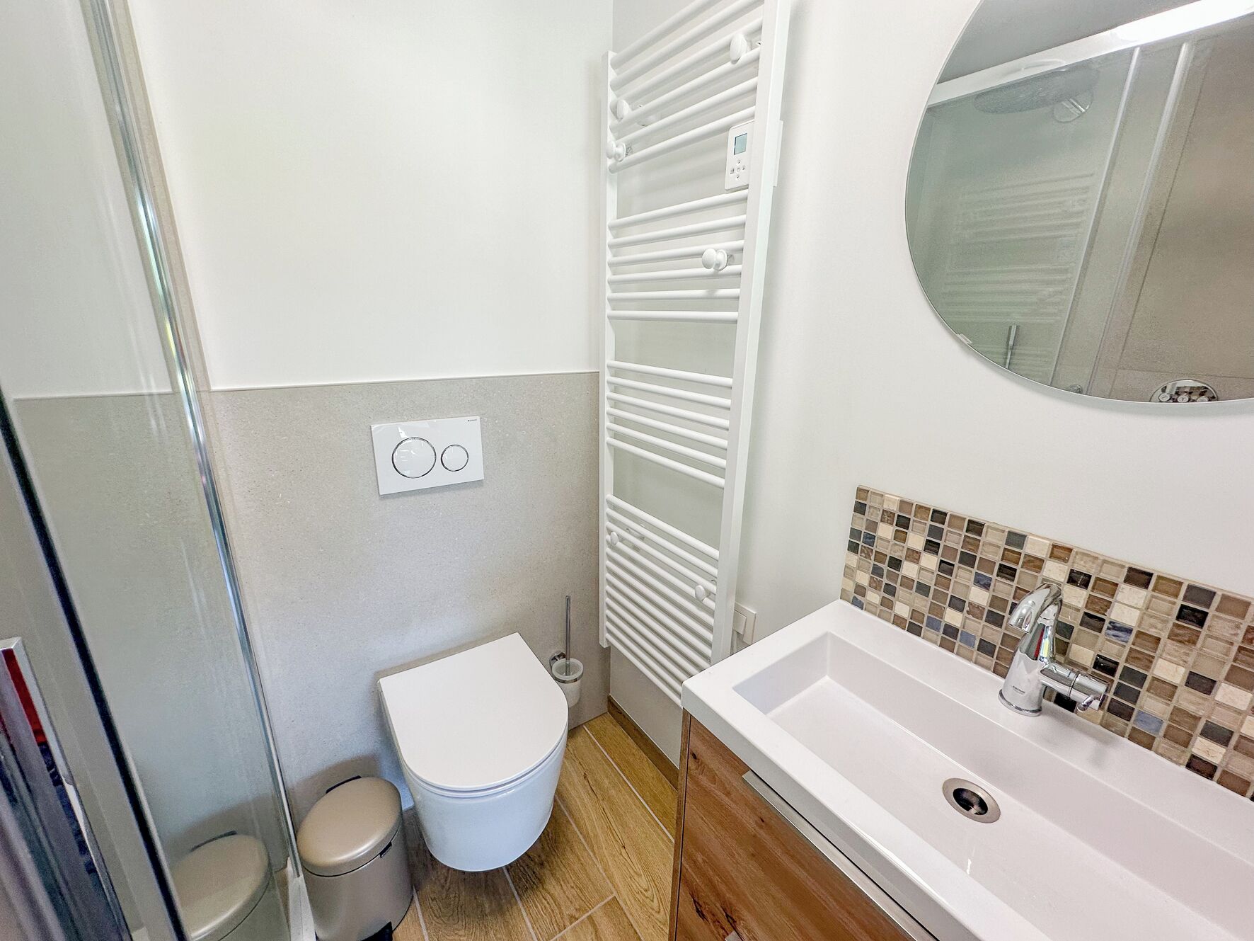 A bathroom with a toilet, bidet, and a sink with a mirror above it.