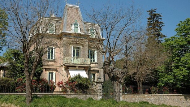 A large, historic building with a symmetrical facade, multiple windows, and a prominent central tower. - Charming House Near Saint-guilhem & Lake Salagou (Saint-Guiraud)