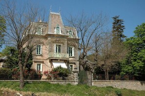 Ein großes, historisches Gebäude mit einer symmetrischen Fassade, zahlreichen Fenstern und einem markanten, zentralen Turm.