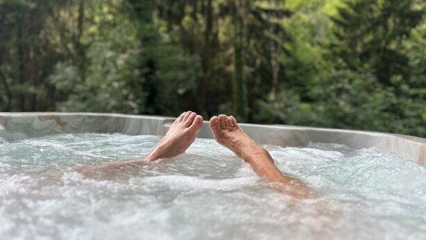 A person relaxing in a hot tub surrounded by a forest. - Cottage by River With Spa Near Carcassonne (Caudebronde)