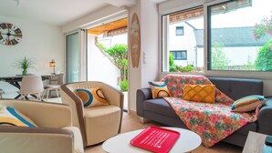 A modern living room with a sofa, armchairs, a coffee table, and a surfboard decoration. - Ideally located in ST Pierre Quiberon, on the bay side. 200 meters from the beach, (Saint-Pierre-Quiberon)