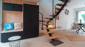 A modern interior with a spiral staircase, a seating area with cushions, and a dining table. - Ideally located in ST Pierre Quiberon, on the bay side. 200 meters from the beach, (Saint-Pierre-Quiberon)