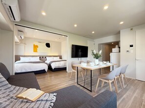 A modern hotel room with a bed, a dining area, and a TV. - Grandeur Hamamoto (Hiroshima)