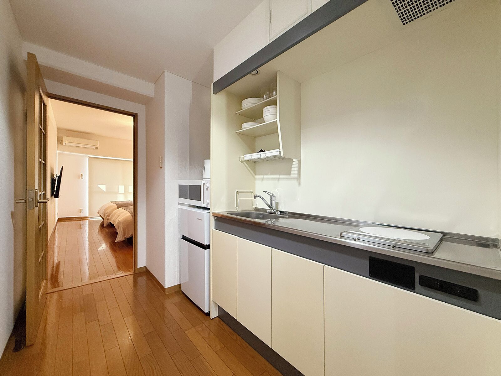 A modern kitchen with white cabinets, a stainless steel sink, and a microwave.