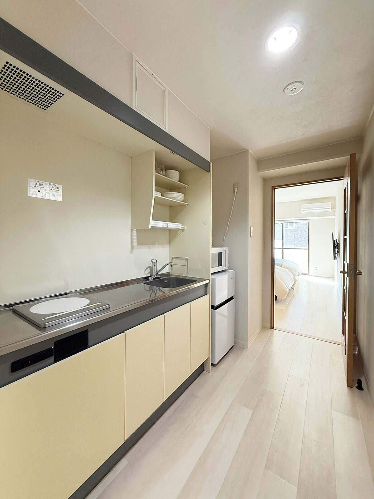 A modern kitchen with a built-in sink, a microwave, and a small refrigerator.