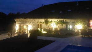 A stone building with a pool in front, illuminated by exterior lights. - Charming renovated farmhouse with large pool (Lacour)