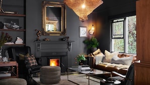 Un salon chaleureux avec une cheminée, un canapé en cuir et un grand miroir.