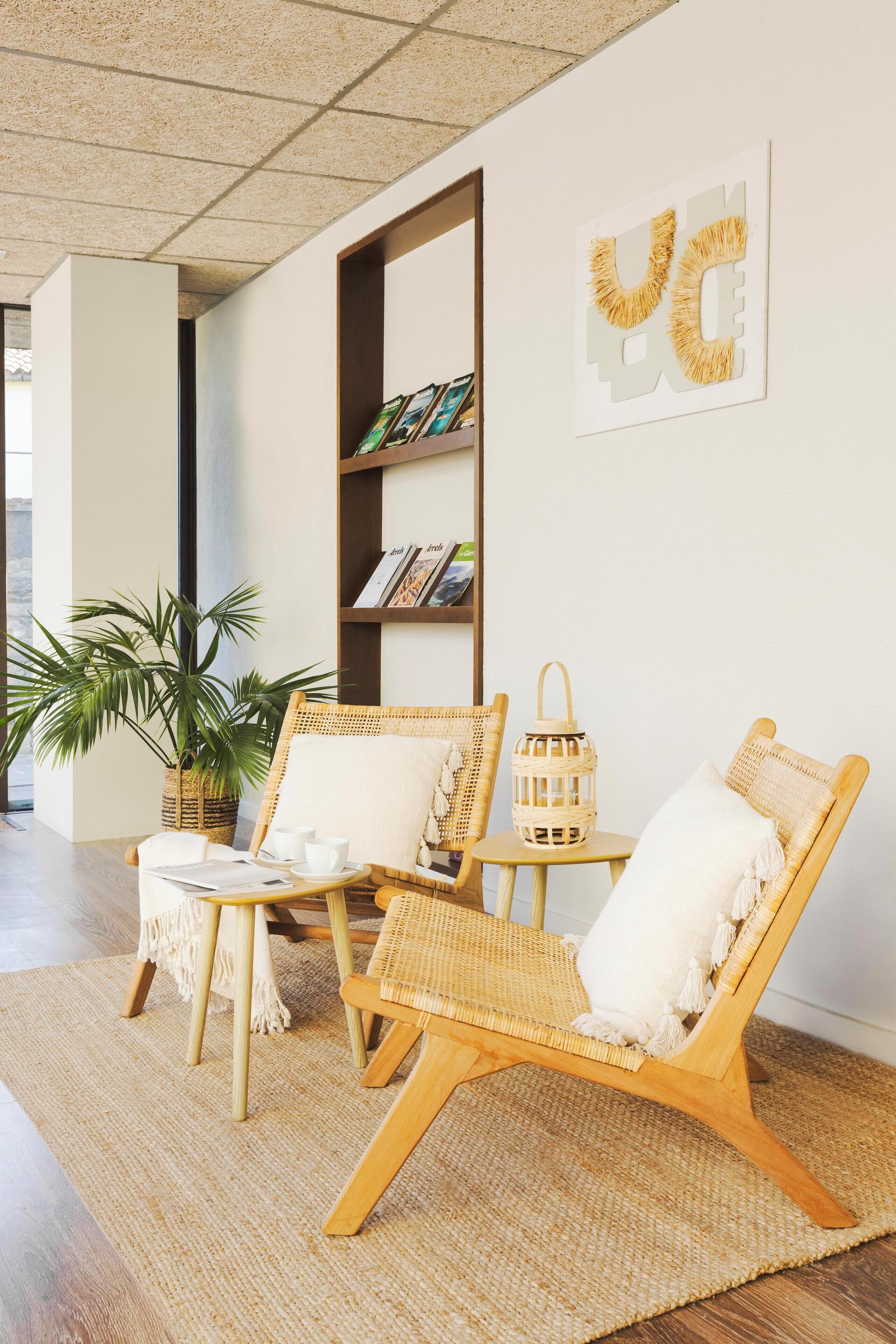 A room with wicker chairs, a woven basket, and a bookshelf.