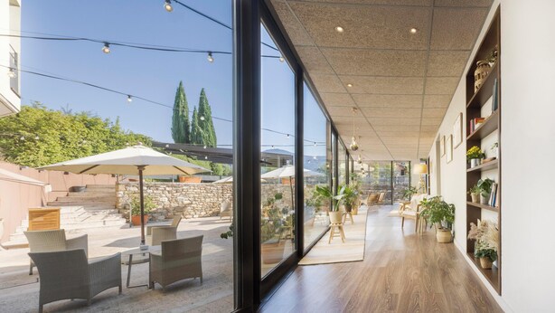Un intérieur moderne avec de grandes fenêtres, des meubles en osier et un plancher en bois.