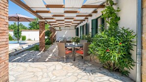 A covered patio with stone flooring, outdoor furniture, and potted plants. - Haus Zdravko in Prkos  - Haus für 4 Personen (Prkos)