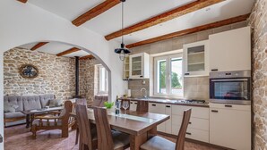 A kitchen with stone walls, wooden beams, and modern appliances. - Haus Zdravko in Prkos  - Haus für 4 Personen (Prkos)