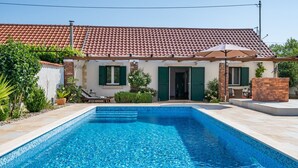 A residential property with a swimming pool, a tiled roof, and a brick wall. - Haus Zdravko in Prkos  - Haus für 4 Personen (Prkos)