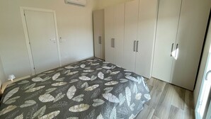 Un dormitorio con cama, armario y aire acondicionado.