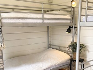 A bunk bed with a single mattress, a black desk lamp, and a potted plant. - 4 Person Holiday Park Home in Vaxholm (Vaxholm)