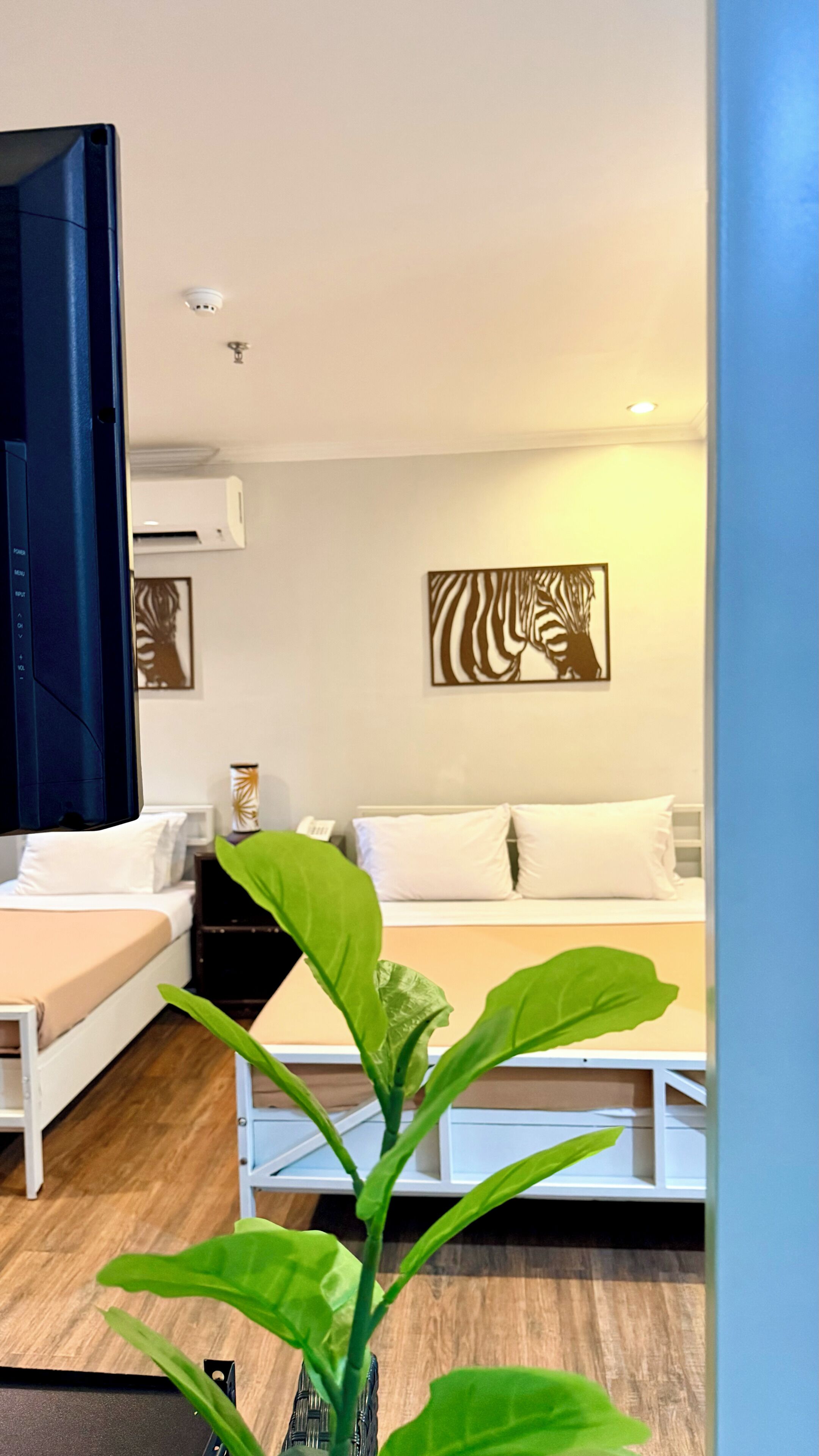 Ein modernes Schlafzimmer mit einem Bett, Nachttisch und einem Wandbild von einem Zebra.