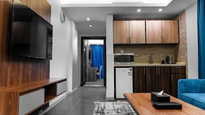 A modern apartment with a living room, kitchen, and a hallway leading to a bedroom. - ALHYAT Hotel (Jeddah)