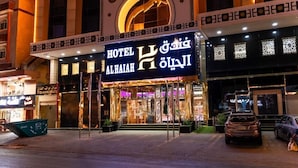 A hotel entrance with a prominent sign, a covered entrance, and a car parked in front. - ALHYAT Hotel (Jeddah)