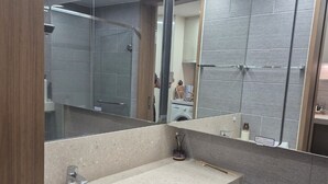 A modern bathroom with a large mirror, a sink, and a toilet. - Beautiful Sunset view in Seongsan Ilchulbong (Jeju-si)
