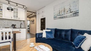 En moderne stue med en mørkeblå sofa, et træbord og en hvid kop.