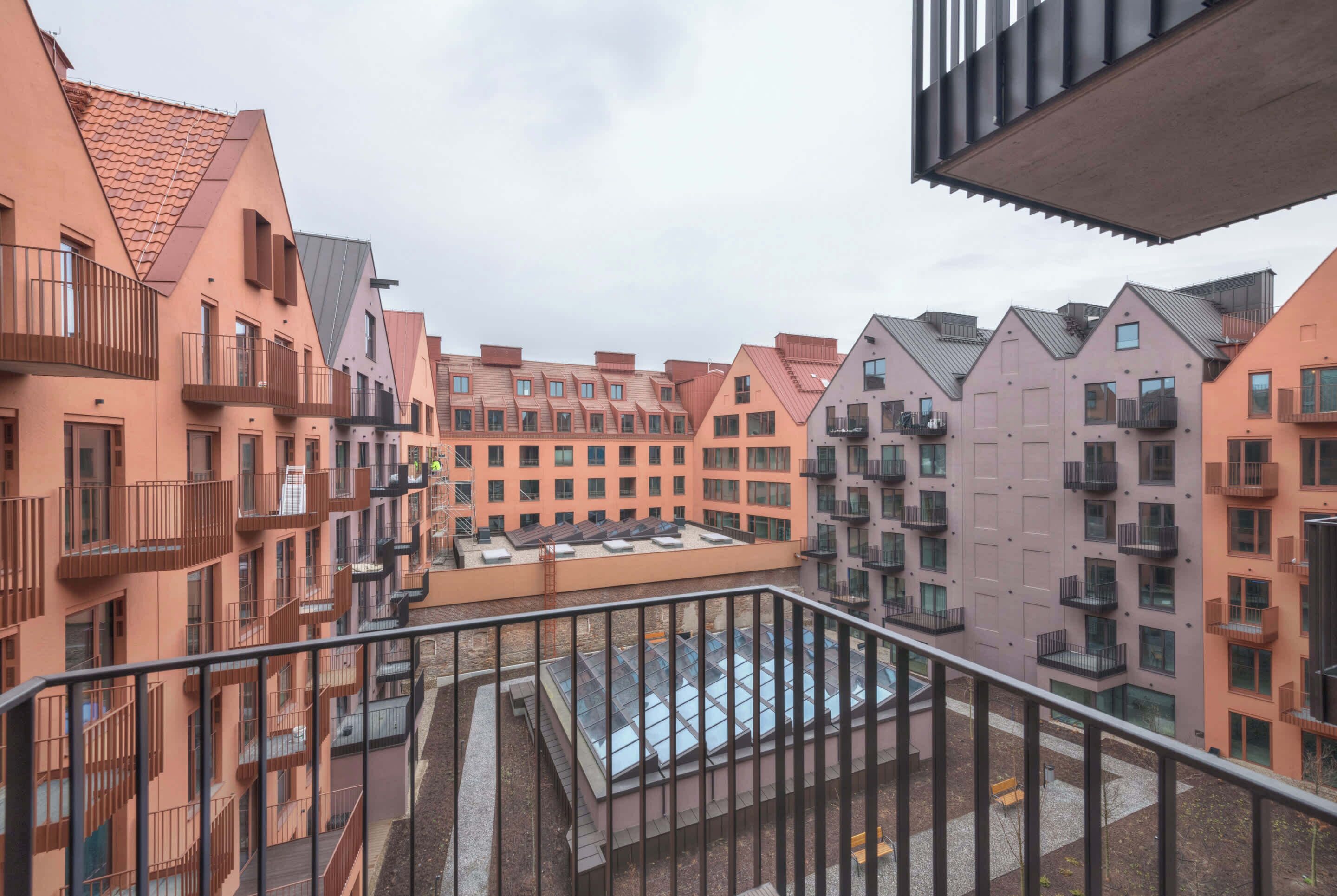 Un edificio residenziale a più piani con balconi, un cortile interno e un tetto piano.