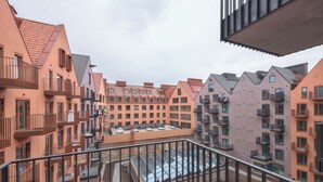 A multi-story residential building with balconies, a courtyard, and a flat roof.