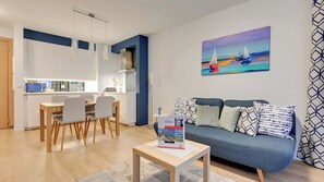 Un salon moderne comprenant un canapé, une table basse et un coin repas avec des chaises et une table.