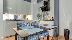 A modern dining area with a glass-top table, matching chairs, and a decorative vase.