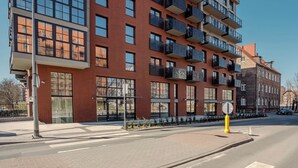 A multi-story building with a brick facade, large windows, and balconies.