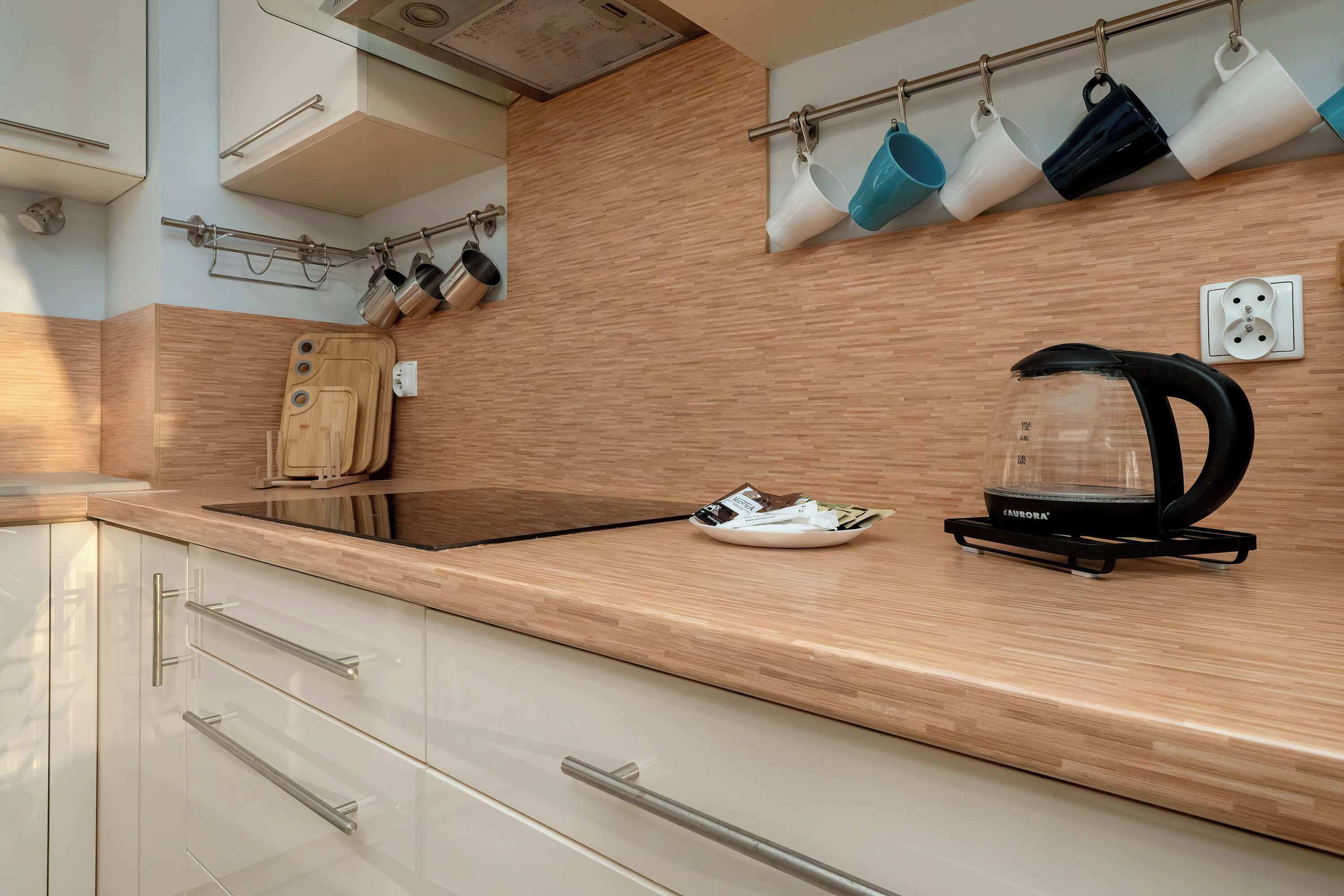 A modern kitchen with a wooden countertop, a coffee maker, and a knife block.