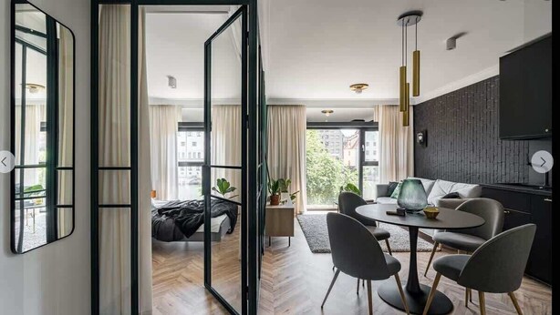 Un salon moderne avec un coin repas, de grandes fenêtres et une vue sur la ville.